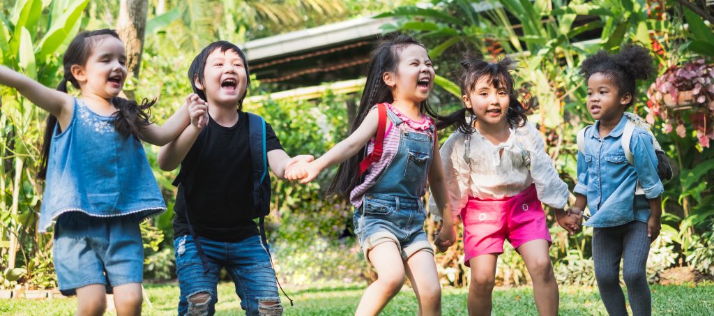 Children looking happy, holding hands.