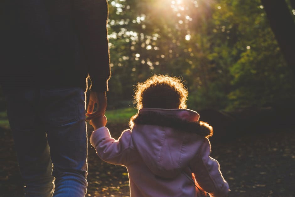 father and daughter holding hands walking