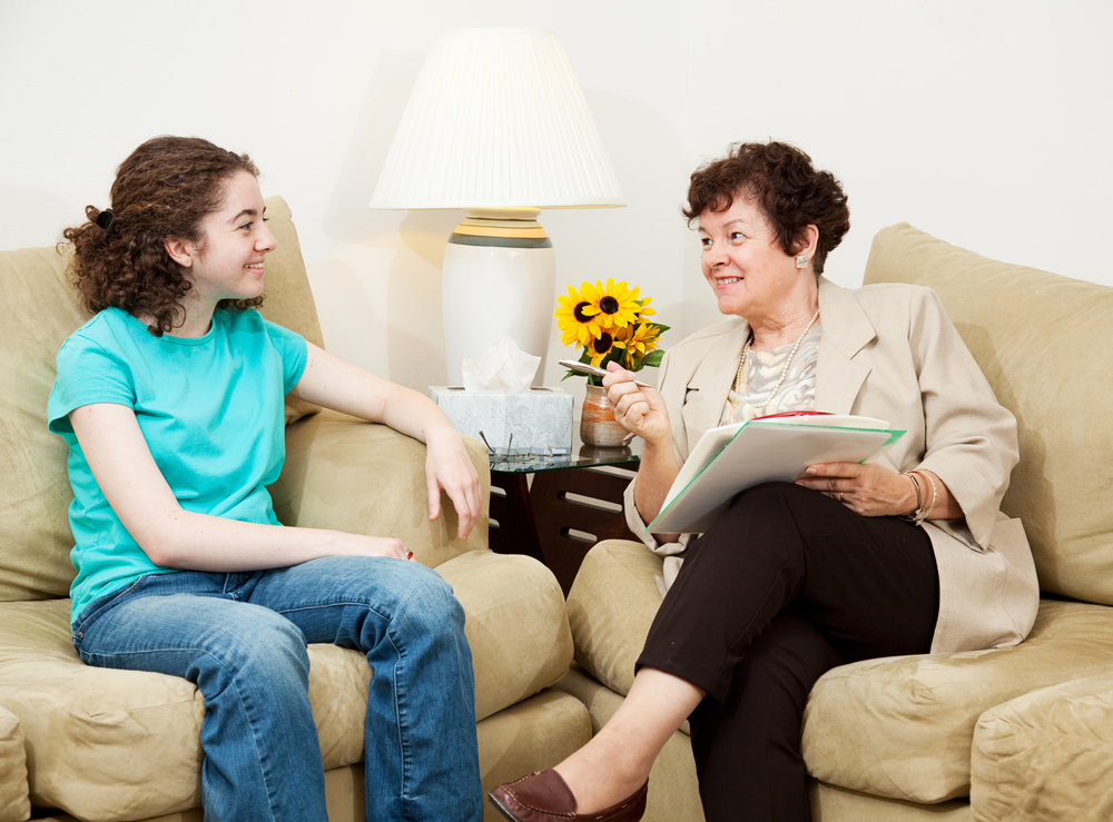 female adult and female child sitting on couches